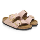 A pair of women's double-strap slide sandals in dusty pink faux leather with gold-tone buckle closures and a cork-look midsole, shown on a plain white background.