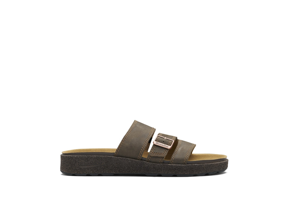 A single dark brown double-strap slide sandal with a metallic buckle detail, shown from a side profile on a solid white background.