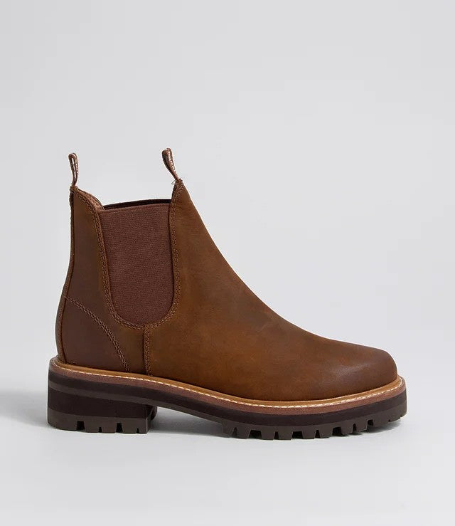 A brown leather Chelsea boot with a dark brown elastic side panel and a chunky lug sole, shown in profile against a light gray background.