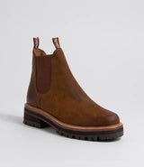 Brown woven Chelsea boot on a light wooden floor