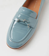 A light blue patent leather penny loafer with a decorative bow detail on the strap, shown on a clean white background.