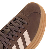 Brown sneaker with white stripes and tan sole on a white background