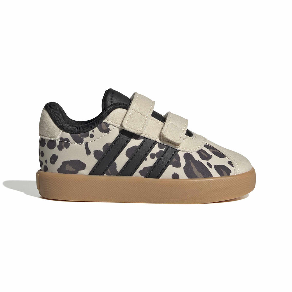 A toddler's low-top sneaker featuring a beige and black animal print pattern, black three-stripes, double hook-and-loop straps, and a gum sole, shown against a plain white background.