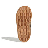 A single brown gum outsole of an Adidas shoe, showing the wavy tread pattern and embossed logo, photographed on a white background with a soft shadow.