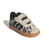 A toddler's low-top sneaker featuring a beige and black animal print pattern, dual hook-and-loop straps, and a gum rubber sole, shown on a white background with a soft shadow.