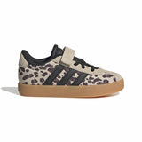 A single Adidas low-top sneaker with a beige and dark brown leopard print pattern, black three-stripes, a black hook-and-loop strap, and a gum sole, shown against a plain white background.