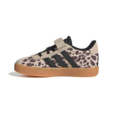 A single Adidas low-top sneaker with a beige and brown leopard print upper, black three-stripes, a beige hook-and-loop strap, black laces, and a gum brown sole, shown against a plain white background.