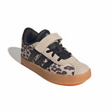 A single children's low-top sneaker with a beige and black leopard print pattern, black laces, a black hook-and-loop strap, and a gum sole, shown on a white background.