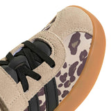Close-up of a low-top sneaker showing the side panel with a beige and dark gray leopard print pattern, black laces, black side stripes, and a gum brown rubber sole on a white background.
