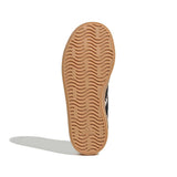 The tan rubber outsole of a shoe, showing the wavy tread pattern and embossed Adidas logo, photographed on a white background with a soft shadow.