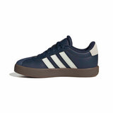 A navy blue Adidas low-top sneaker with three white stripes, a navy laces and collar, a light gray heel tab, and a brown gum sole, shown from a side profile on a white background.