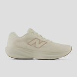 A New Balance running shoe in off-white with a dusty rose pink 'N' logo on the side, shown from a profile view against a light gray background.
