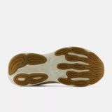 The outsole of a sneaker, showing a brown textured tread pattern over a white and beige midsole, photographed on a light gray background.